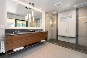 A modern bathroom with a wooden vanity, a large mirror, and a glass shower enclosure. - Relaxing in Paradise w Private Roof Top Deck!! (Fort Collins)