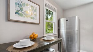 A kitchen with a stainless steel refrigerator, a bowl of oranges on the counter, and a framed artwork above the counter. - Charming Old Town Bungalow w/ FREE Cruiser Bikes (Fort Collins)