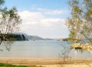 Enjoy a serene lakeside view with a sandy beach and rocky outcrop.