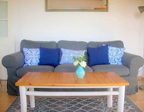 Relax in this stylish living room with a sofa, coffee table, and vibrant artwork.