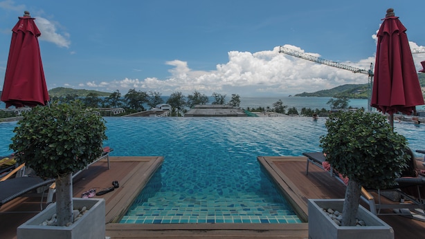 A swimming pool with a view of a bridge and distant hills.