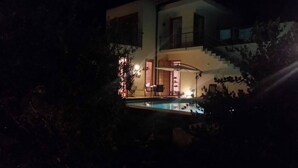 Ein modernes, zweistöckiges Haus mit sichtbarer Treppe und einem Swimmingpool.