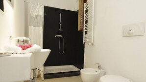Ein modernes Badezimmer mit Badewanne, Bidet und Toilette.