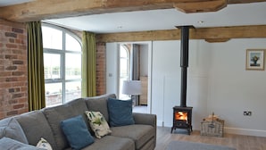 Una sala de estar acogedora con un sofá, una chimenea y vistas por la ventana.
