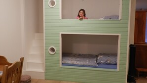 A room with a bunk bed and a small round window. - Assisihof - Apartment zur Linde (Friedeburg)