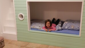 A child lying in a bunk bed with a star-patterned mattress. - Assisihof - Apartment zur Linde (Friedeburg)