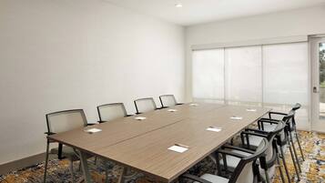 Una sala conferenze con un lungo tavolo, sei sedie e un'ampia finestra.