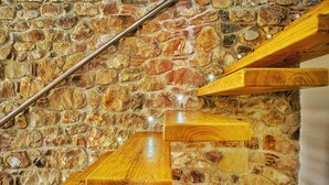 A wooden staircase with a stone wall background. - La Villa Del Borgo Cefalù (Cefalù)