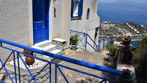 A coastal building with a blue door, white walls, and a view of the sea. - Villa Iokasti Sea View (Corinth)