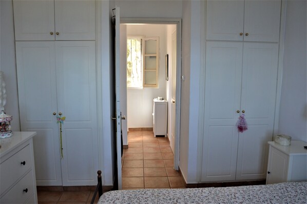 A bedroom with a bed, a wardrobe, and a dresser.