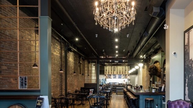 A restaurant interior with wooden floors, brick walls, and a bar area. - Broken Hill Designer Baker St Flat Mountain View.  (Nelson)