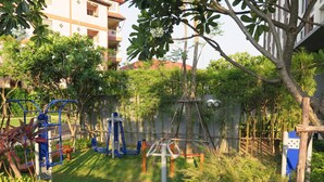 A playground with exercise equipment, surrounded by greenery and residential buildings. - 3008 - 1 Bedroom Seaview Apartment, Unixx Pattaya (Pattaya)