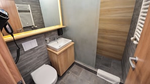 Une salle de bain moderne avec un meuble-lavabo en bois, un lavabo blanc et des toilettes.