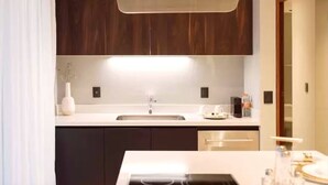 A modern kitchen with dark wooden cabinets, a white countertop, and a built-in dishwasher. - It Residence, 2 Bedroom Apartment with Rooftop Pool (Playa del Carmen)