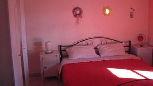 A bedroom with a bed, nightstands, a door, and wall decorations. - A Relaxing Holiday, Even With Your Four-legged Friends (Avola)