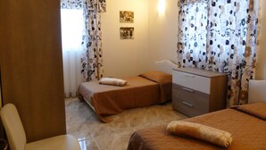 Une chambre d’hôtel avec deux lits, une commode, une chaise et une petite table.