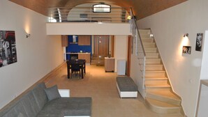 A spacious living area with a sofa, a coffee table, and a staircase leading to an upper level. - Corona Matera Holiday Home (Matera)