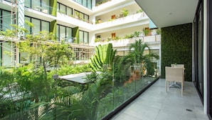 A multi-level atrium with lush greenery, glass railings, and modern architecture. - Lovely One Bedroom With Amazing Terrace View!! (Playa del Carmen)