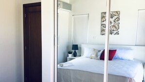 A bedroom with a bed, a nightstand, a lamp, and a door. - Sosua Ocean Vilage Villa With 2 Bedrooms And Privat Pool (Sosúa)