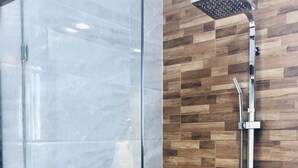 A modern bathroom with a glass shower enclosure, a wooden wall, and a potted plant. - Sosua Ocean Vilage Villa With 2 Bedrooms And Privat Pool (Sosúa)