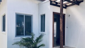 A white building with two windows and a wooden pergola. - Sosua Ocean Vilage Villa With 2 Bedrooms And Privat Pool (Sosúa)