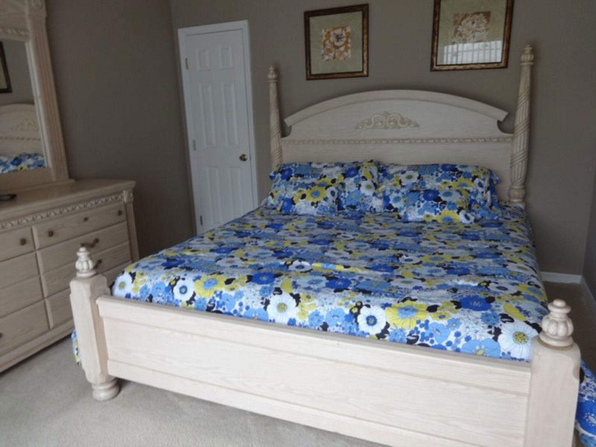 Un dormitorio con cama, cómoda y puerta.