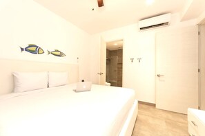 A bedroom with a bed, a laptop, a shower, and an air conditioning unit.