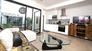 Uma sala de estar moderna com uma mesa de centro de vidro, um sofá e uma televisão.