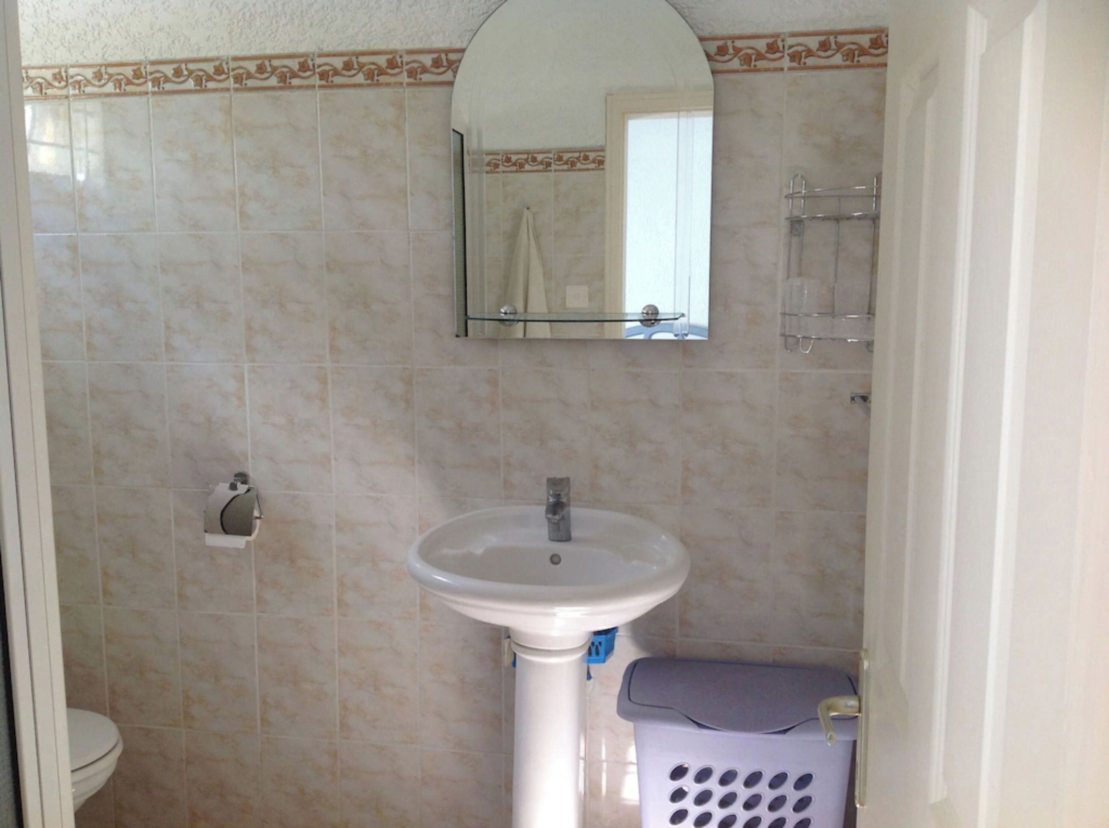 A bathroom with a sink, toilet, and a mirror above the sink.