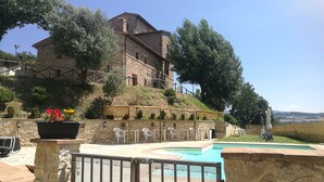 A stone building with a pool, outdoor seating, and a view of the landscape. - Apartment Iris 3 Bedrooms,2 Bath, Living Room 10 Pax (Monte Castello di Vibio)