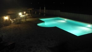 A swimming pool at night with a stone patio and outdoor furniture. - Apartment Iris 3 Bedrooms,2 Bath, Living Room 10 Pax (Monte Castello di Vibio)