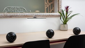 A conference table with three black spherical objects, a potted plant, and a mirror with a decorative frame. - Boutique Home-splantzia- Roof Garden-2min Chania Harbor (Chania)