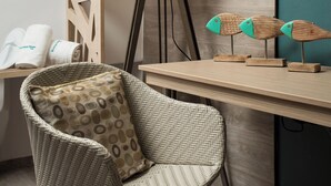 A room with a wicker chair, a lamp, a wooden desk, and a wall-mounted rack with hangers. - Boutique Home-splantzia- Roof Garden-2min Chania Harbor (Chania)
