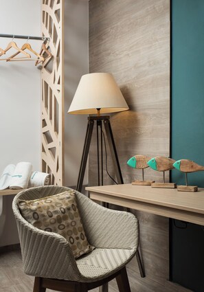 A room with a wicker chair, a lamp, a wooden desk, and a wall-mounted rack with hangers. - Boutique Home-splantzia- Roof Garden-2min Chania Harbor (Chania)