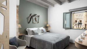 A bedroom with a bed, two wall-mounted lamps, a window with a view, and a wooden side table with cups. - Boutique Home-splantzia- Roof Garden-2min Chania Harbor (Chania)