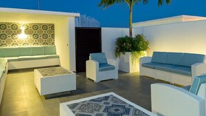 A rooftop terrace with a modern white and blue color scheme, featuring a sofa set, a coffee table, and a decorative plant. - Classy 2 Br Apartment Fully Equipped, Up To 5 People, at Aldea Zama (Tulum)