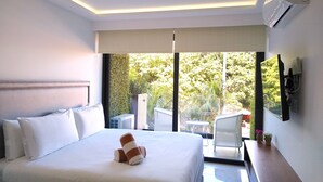 Hotelkamer met een groot bed, een flatscreen televisie aan de muur en uitzicht op het omliggende landschap.