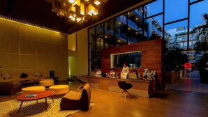 A modern lobby with a reception desk, seating area, and large windows. - Studio Close to 5th Av, With Amazing Roof Pool View, Gym, Spa and More! (Playa del Carmen)