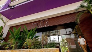 A modern building with a sign reading "The City Condos." - Studio Close to 5th Av, With Amazing Roof Pool View, Gym, Spa and More! (Playa del Carmen)