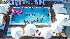 A swimming pool with 'MARTINA' written on the water, surrounded by white umbrellas and lounge chairs. - Studio Close to 5th Av, With Amazing Roof Pool View, Gym, Spa and More! (Playa del Carmen)