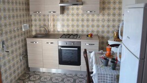A kitchen with patterned wallpaper, a stove, oven, and a refrigerator. - Beautiful Apartment On The Beach In Central Location With Spacious Balcony Pets (Melendugno)