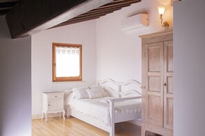 A bedroom with a white bed, a nightstand, a wardrobe, and a window with heart-shaped decorations. - Bilocale 30 Metri Dalla Spiaggia (San Vincenzo)