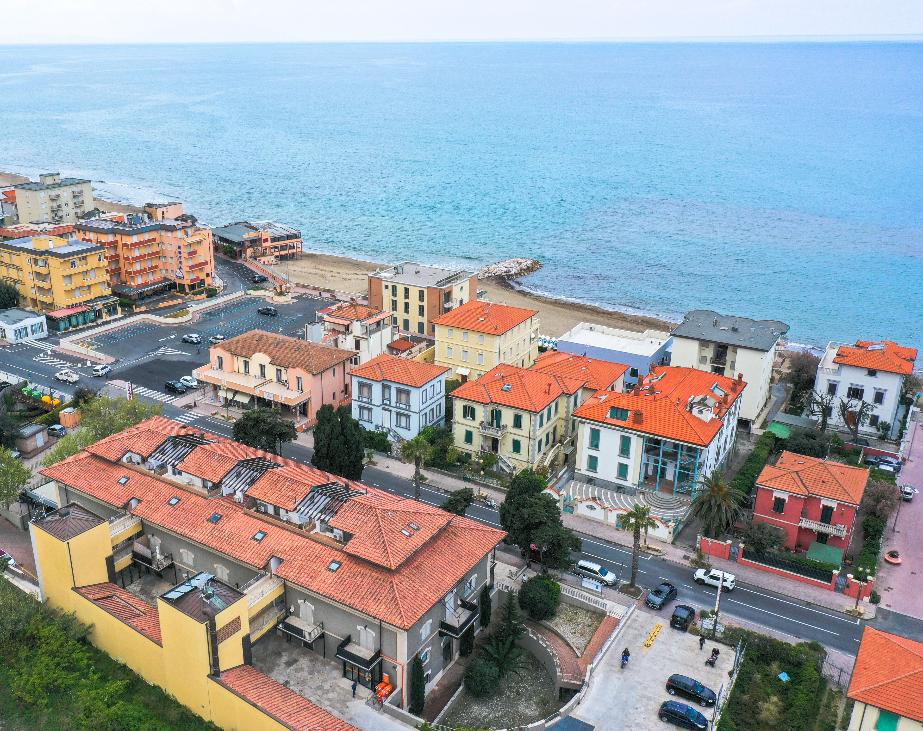 A coastal town with colorful buildings, a beach, and a view of the sea.