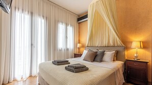 A neatly made bed with a canopy, a bedside lamp, and a wooden nightstand. - Villa Kallisto With Private Pool And Stunning Sea Views (Skiathos)