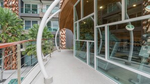 Um edifício moderno com elementos arquitetônicos curvos, grandes janelas e fachada de vidro.