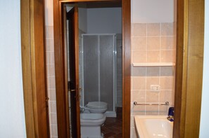 A bathroom with a toilet, shower, and sink. - Apartment With Private Garden in Tuscany (Asciano)