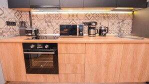 Een moderne keuken met een magnetron, koffiezetapparaat en oven.