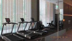 A gym with treadmills, exercise bikes, and a mirrored wall. - 3337 - Downtown Studio Apartment, Unixx Pattaya (Pattaya)