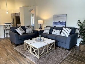 A modern living room with a sectional sofa, a coffee table, and a lamp. - A Wonderful Choice for a Family Vacation, 4 Bedrooms and it own Pool (Clermont)