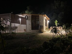 Un petit bâtiment d’un seul étage, doté d’un patio, d’une barrique en bois et d’une table avec des chaises.